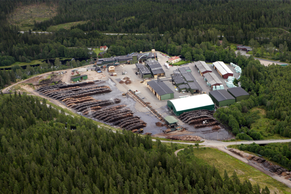 Flygvy över en fabrik omgiven av skog. Foto.