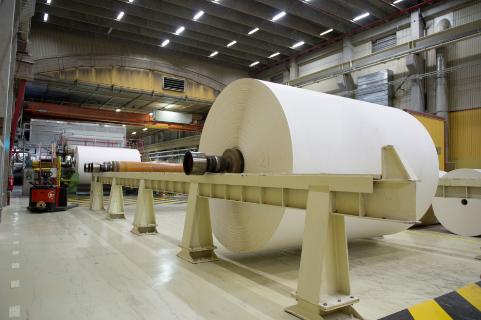 En stor pappersrulle uppsatt på en maskin i ett pappersbruk.
